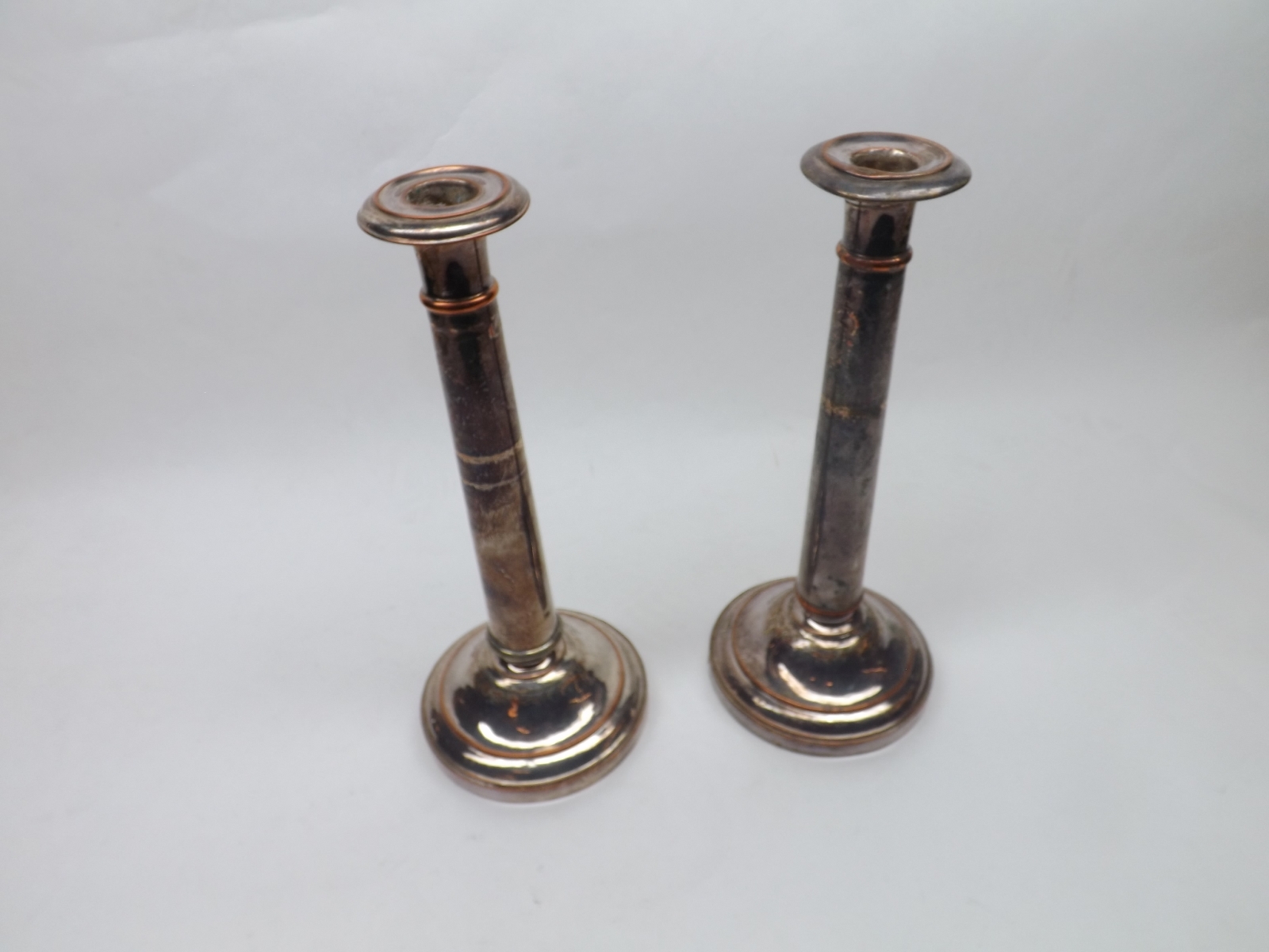 A pair of 19th Century Silver Plated on Copper Tapering Circular Candlesticks, with loaded bases,