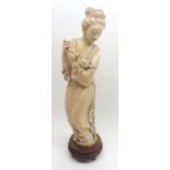 Late 19th Century Okimono carved in the form of a young woman clutching a sprig of foliage and a