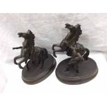 A pair of Bronzed Spelter Models of figures with rearing horses, raised on oval bases, 8" high
