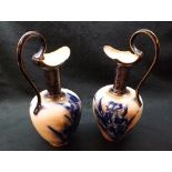 Pair of Doulton Burslem decorative Ewers, the bodies decorated with stylised blue foliage on a