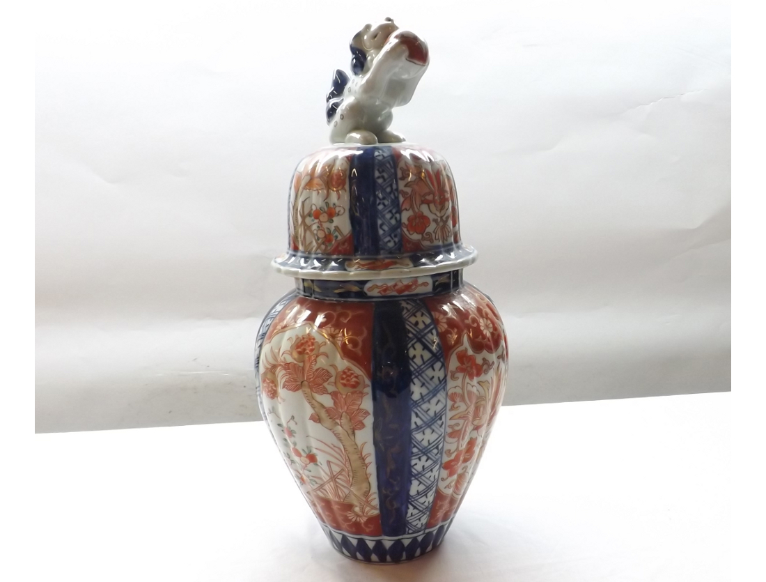 A Japanese Imari covered Jar of reeded tapering circular form, typically decorated in traditional