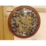 An Oriental Circular Wirework and Silkwork Panel depicting a coiled dragon and smoke clouds, in a