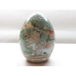 A Chinese Porcelain Large Ornamental Egg, painted predominantly in famille verte and puce with
