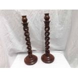 Pair of Mahogany stained candlesticks with spiral twist stems terminating in domes spreading