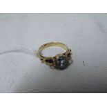 A high grade precious metal Ring set with an Emerald Cut Blue Stone, pierced shoulders, marks
