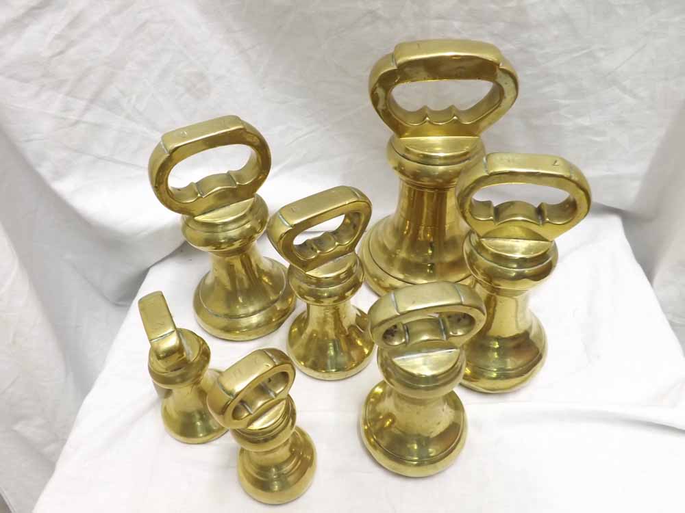 Graduated collection of seven various bell-shaped Brass weights, the largest from 1 Stone down to