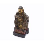 A Chinese Carved Hardwood Figure of a seated warlord on his throne, decorated throughout with gilded