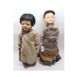 A pair of mid-20th Century Painted Composition and Cloth Bodied Japanese Dolls in traditional dress,