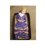 A painted papier-m ch and composition doll with fixed blue glass eyes, short blonde wig, painted
