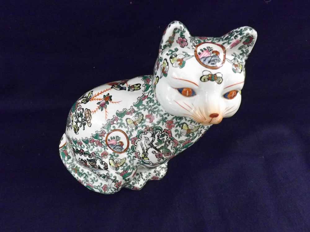 An Oriental Model of a seated cat, decorated predominantly in famille rose and verte, 11" high