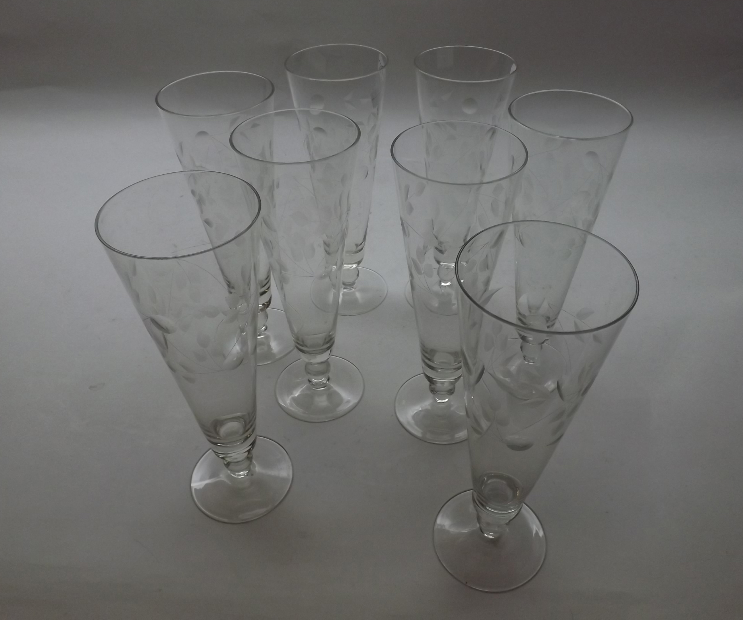 Set of eight 20th Century tapering glasses of circular form, raised on spreading bases, decorated