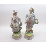 A pair of late 19th Century Continental Figures of lady and gent in period dress, raised on circular