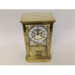 A late 19th Century French lacquered Brass four-glass Mantel Clock, the plinth shaped case set