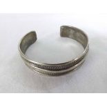 An Ethnic white metal Torc design Bangle with chevron styled channel decoration