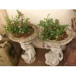 Pair of contemporary composition garden urns, with spreading bowls raised on cherub formed supports,