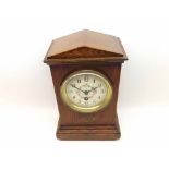 An early 20th Century Oak cased timepiece, the case with architectural pediment and overhanging