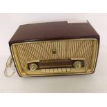A mid-20th Century Grundig type 97 radio in burgundy and cream hard plastic case, fabric covered