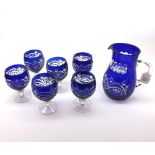 A 20th Century clear and blue glass Water Jug and six glasses all decorated with cut detail, 8” high