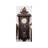 A late 19th Century Walnut cased twin weight Vienna type Wall Clock, the case with overhanging