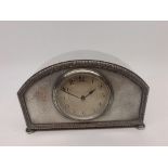 A first half of 20th Century electro-plated mantel timepiece, the arched case raised on compressed