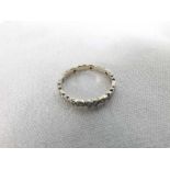 A high grade precious metal all small Brilliant Cut Diamond Surround Eternity Ring, stamped "18ct"