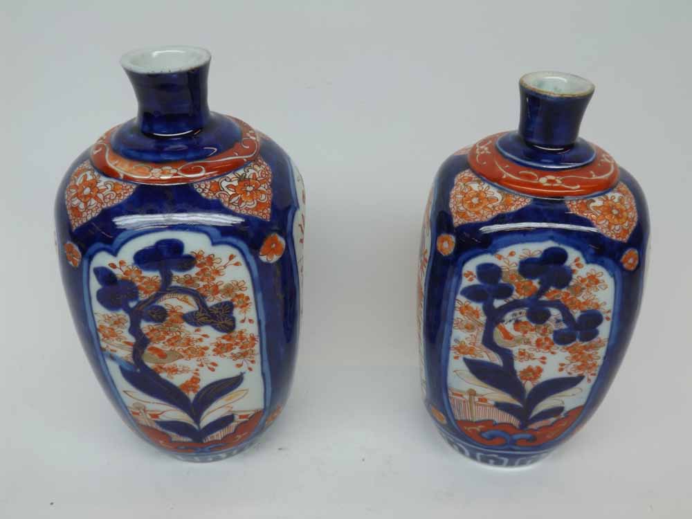 A near pair of Japanese Imari Baluster Vases of shaped square form, painted in colours in the