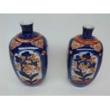 A near pair of Japanese Imari Baluster Vases of shaped square form, painted in colours in the
