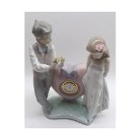 A Lladro Clock Group, young man presenting a bunch of flowers to a shy girl, with clock between, 9