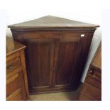 An Oak Corner Cupboard, two panelled doors enclosing fitted interior, 38" wide