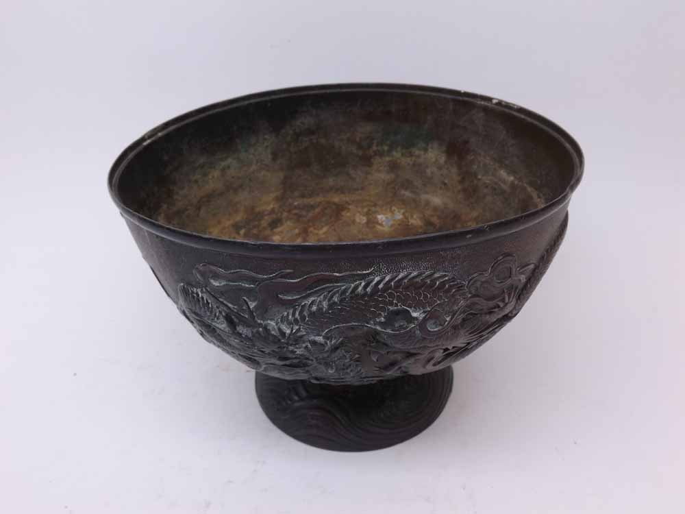 An Oriental Antimony Bowl of pedestal form, embossed with dragons and smoke clouds, 7 1/2" diameter