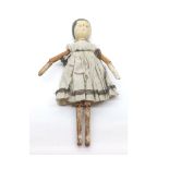A mid-19th Century Wooden Peg Doll with painted features, on wooden body with articulated arms and