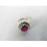 A hallmarked 18ct Gold Centre Oval Ruby (approx 10mm x 8mm) and fourteen Brilliant Cut Diamonds in