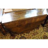 An 18th Century style Oak gate leg Dining Table, the frieze fitted at one end with a drawer and