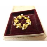 A good quality high carat yellow metal and Pearl set open work circular Brooch of conjoined leaf