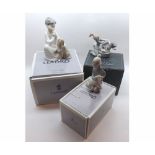 Three Lladro Models: Girl soaping a seated dog in a bath tub; Kneeling boy with lamb; Kneeling boy