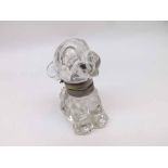 An early 20th Century Moulded Glass Ink Bottle and Lid, in the form of Bonzo the Dog, he wears a