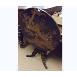 Black lacquered and gilded tilt top pedestal table of circular form, decorated with exotic birds and