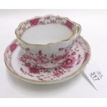 A Meissen Cup and Saucer painted in puce with stylised floral design on a white ground with gilded