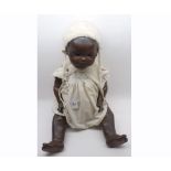 A black Armand Marcel Bisque socket head Doll with fixed brown glass eyes, painted lashes and brows,