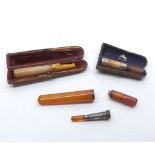 A Mixed Group of five assorted Cigar/Cheroot Holders, some with silver bands, largest piece 3 1/2"