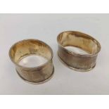 A pair of George V Napkin Rings, oval shaped with engine-turned decoration, each engraved with the