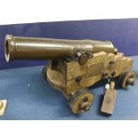 A Vintage Brass Short Barrelled Cannon on a hardwood four-wheeled carriage, applied on one side with