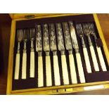 A cased set of twelve Silver Plated and Ivorine handled Dessert Knives and Forks, decorated with