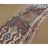 A Kilim Large Runner or Wall Hanging, decorated with interlinked lozenge panels within a three-sided