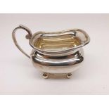 Elizabeth II Silver Cream Jug of tapering form with scrolled handle, raised on four small bun