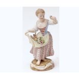 A Meissen Figure of a female flower seller with floral sprigs in the fronds of her apron and