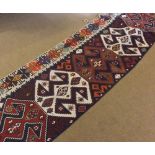 A Kilim Wall Hanging or Runner, decorated with panel of interlinked lozenges, with a border only