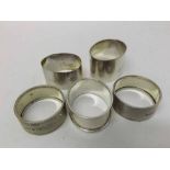 Mixed lot comprising five assorted Silver Napkin Rings of varying designs, to include pair with