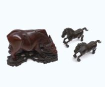 An Oriental Hardwood Carved Model of an ox standing on carved plinth, together with two Oriental