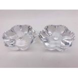 A pair of Orrefors rosette-shaped plain glass candlesticks of tapering form, each with etched bases,